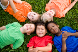 Children with Brightly Colored Shirts Lying in Grass